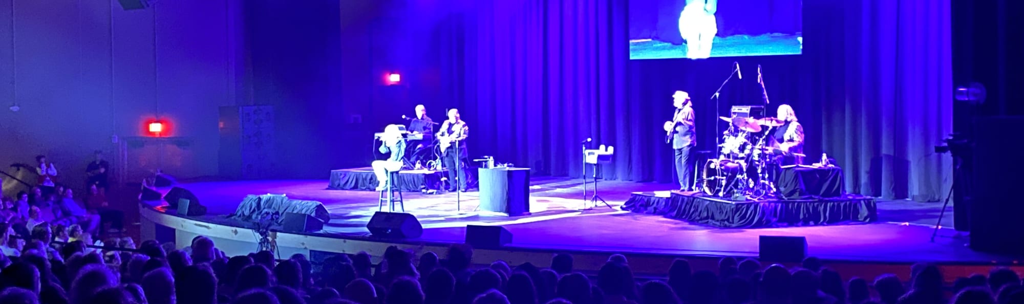 signer on stage in chair washed out by the lights Morgantown